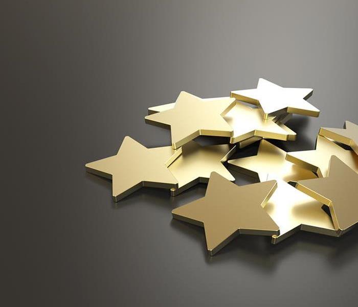 gold stars in a pile with a gray background.