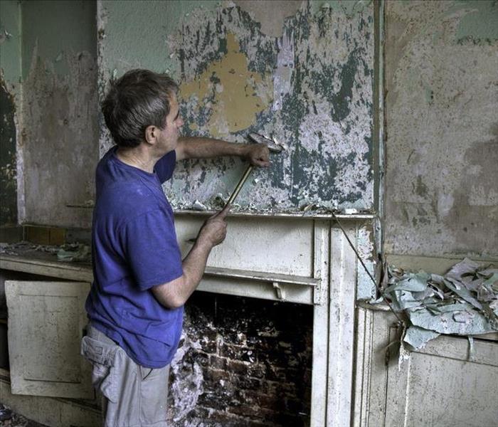 a man removing asbestos in an old home.